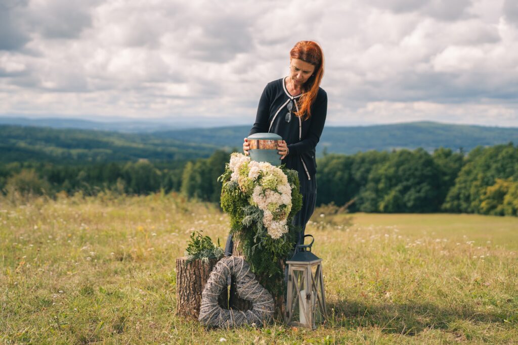 Přírodní pohřeb: Petra ukládá urnu na rozkvetlé louce s výhledem do lesů.