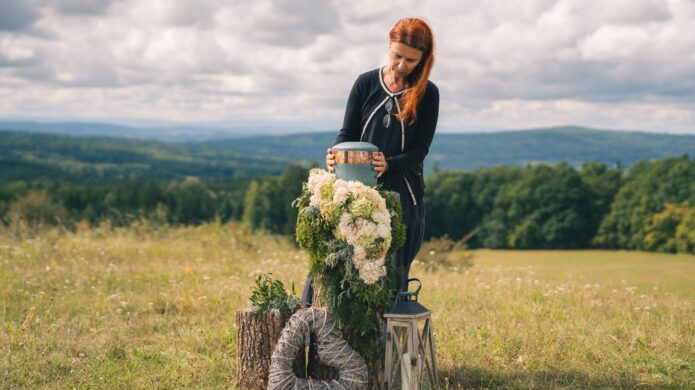 Přírodní pohřeb: Petra ukládá urnu na rozkvetlé louce s výhledem do lesů.